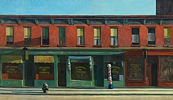 An empty city street lined with storefronts in the early morning light