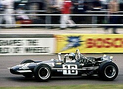 A mid-engined single-seater racing car with modest aerodynamic wings