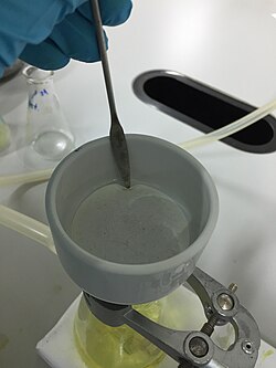 This is one of many uses of stainless steel spatula: it can be used to aid the removal of filter paper from vacuum filtration.