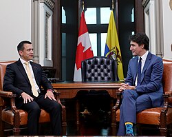 Noboa and Justin Trudeau are sitting together at a negotiation table.