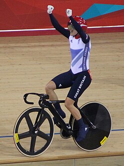 Pendleton holds her arms aloft while riding her bike