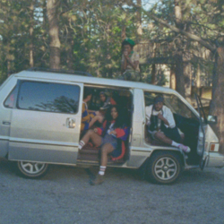 Cover art for "Broken Clocks": SZA and a group of people gathered inside a camper van