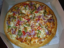 A pizza with paneer and vegetable toppings