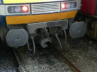 British-style dual buffer-and-chain/semi automatic coupler with knuckle swung out of the way (drop head)