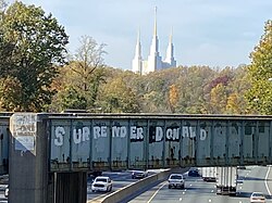 Washington LDS Temple as seen from Interstate 495. The graffiti was updated to say Surrender Donald