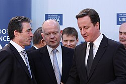 Cameron with William Hague speaking to Anders Fogh Rasmussen at the London Conference on Libya in March 2011