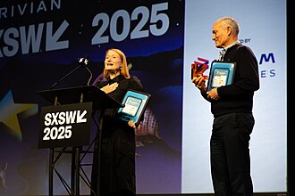 Dr. Laura Hosman and Bruce Baikie, co-founders of SolarSPELL, receive the award for "Best in Show" at the 2025 South by Southwest Innovation Awards.