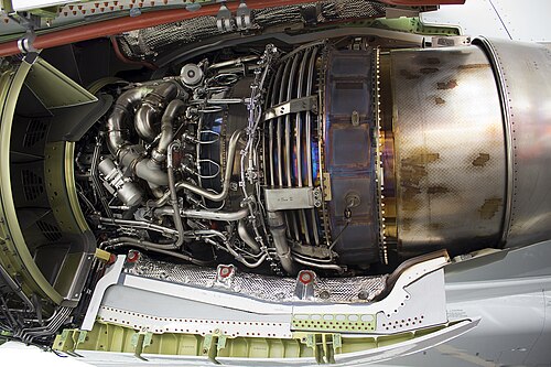 This view shows the way turbine blade tip clearance is controlled actively (passive control is by material selection and internal air system cooling) using cooling-air tubes (for low pressure turbine blade tip to shroud clearance control) which circle the iridescent turbine casing on a CFM International CFM56. Cooling air manifold (smooth flat surface), to left of LPTCC tubes, for high pressure turbine blade tip clearance control.[124] Active control comes from activation of valves which supply cooling air to the tubes at appropriate flight conditions.