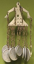 A pendant made of Japanese coins, brass, aluminum and glass