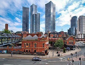 Deansgate Square with multiple skyscrapers and bridges. The image provides a brighter view of the cityscape.