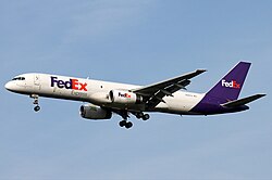 Side view of a white and purple twin-engine jet in flight