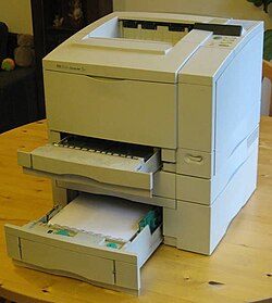 HP Laserjet 5 printer set up on a desk with its trays open
