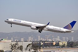 Side view of twin-jet aircraft ascending.