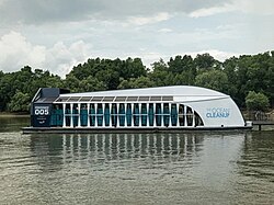 White and black plastic collection boat on a river