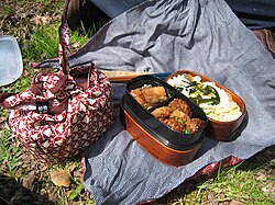 Two typical homemade bento (one open, one wrapped) with furoshiki cloths