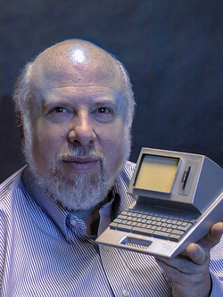 Jef Raskin holds a model of the Canon Cat.