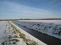 A village catchwater drain shown during the winter season