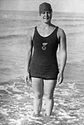 A woman wearing a tank top and pants