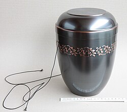A cinerary urn. The laces are used to lower the urn into the ground