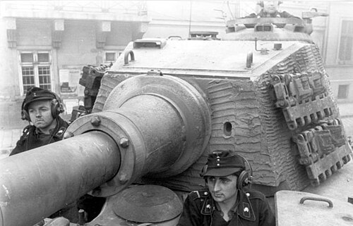 A tank turret with an almost square, flat, vertical face, the sides are almost vertical, and curve laterally only slightly