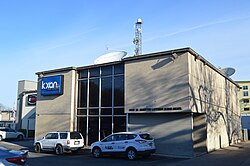 A two-story, 1960s-vintage building with KXAN signage and KBVO signage also visible