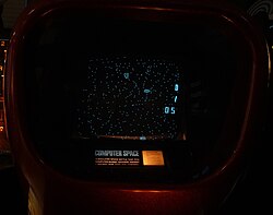 Photograph of gameplay, with white dots on a black screen and instructions below