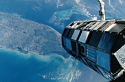 Large, cylindrical spacecraft against Earth background, photographed from the Challenger space shuttle