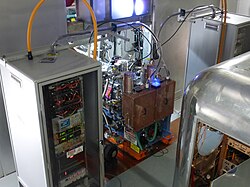 Two ion sources at the center with two high-voltage electronics cabinets next to them[40]