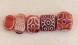 Indian carnelian beads with white design, etched in white with an alkali through a heat process, imported to Susa in 2400–2100 BC. Found in the tell of the Susa acropolis. Louvre Museum, reference Sb 17751.[63][64] These beads are identical with beads found in the Indus Civilization site of Dholavira.[65]
