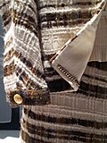 A 1965 Chanel suit showing the chain that is a distinctive technique for constructing a Chanel suit. It gives even light-weight materials a good drape and stabilize the suit as it weighs down the hem.[118][119]