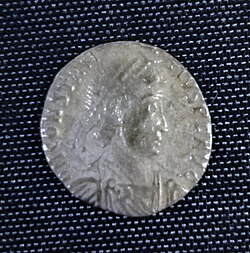 A smaller silver coin in the centre a head - still a fairly round coin but the inscription is not intact and there is no space between it and the rim