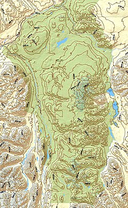A yellow and green map with contour lines depicting a mountainous environment