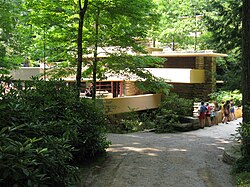 A view of the bridge leading to the entrance of Fallingwater, as seen from across the Bear Run stream. The bridge is at right, and Fallingwater is to the left.