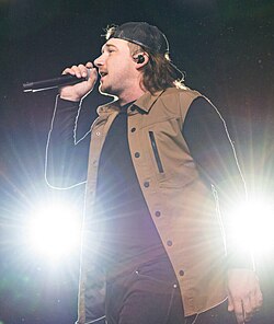 Wallen holding a microphone on stage.