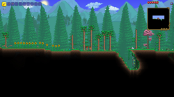 A screenshot of Terraria, showcasing trees, sunflowers, the player character and the guide non-playable character
