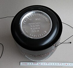 A sealed cinerary urn, showing the ash capsule containing the remains of the dead, along with the name and dates