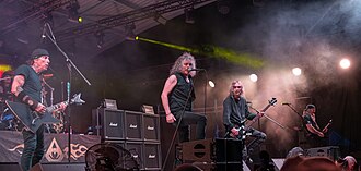 Band members performing on stage in 2024