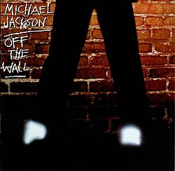 Against a brick wall, a man's bottom half of his legs, glowing socks, and black shoes are visible. It is cut from the original cover, and was also the original back cover.