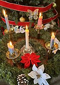 Advent wreath with one rose candle and three blue ones, plus a central white one