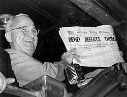 Harry S. Truman gleefully displays a Chicago Tribune headline erroneously stating that his opponent, Thomas E. Dewey, defeated him in the United States presidential election.