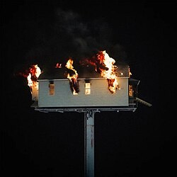 A burning house shown over a black background
