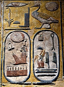 A stone face carved with coloured hieroglyphics. Two cartouches - ovoid shapes with hieroglyphics inside - are visible at the bottom.