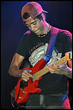 Greg Howe using a scrunchie on the first fret to mute the open strings while tapping with two hands