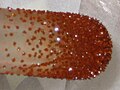 Image of deep red-orange, freshly vaccuum-sublimed ferrocene crystals on a cold-finger condenser.