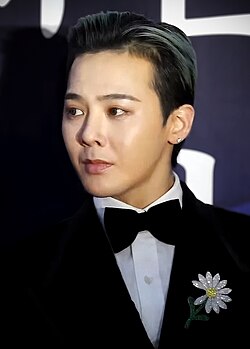 G-Dragon wearing a suit and looking towards the left