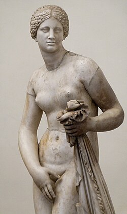 A stone carving of a nude woman, covering her vulva with one hand