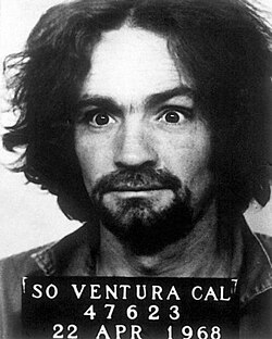 Mug shot of Manson, where he holds a sign reading "SO VENTURA CAL - 47623 - 22 APR 1968"