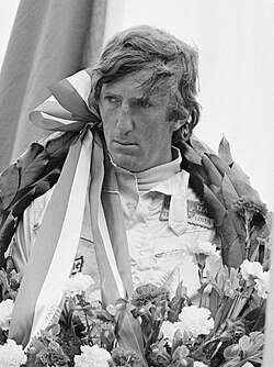 Photograph of Jochen Rindt on a winner's rostrum with a laurel wreath around his neck
