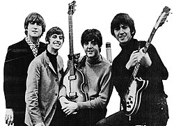 A black and white photograph of the Beatles holding their guitars.