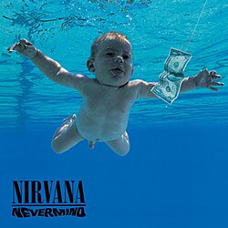 A nude infant swimming in blue-tinted water toward a dollar bill which is attached to a fishhook on a string.